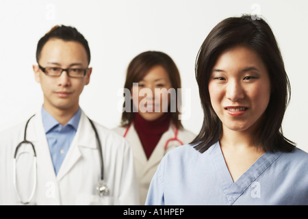 Porträt von einer Krankenschwester mit zwei Ärzten, die hinter ihr stehen Stockfoto