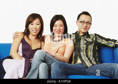Nahaufnahme von einem jungen Mann und zwei junge Frauen sitzen auf einer couch Stockfoto