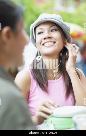 Junge Frau anhören von Musik in einem Restaurant im freien Stockfoto