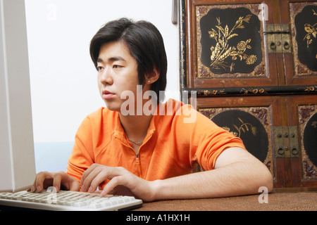 Junger Mann mit Hilfe eines Computers Stockfoto