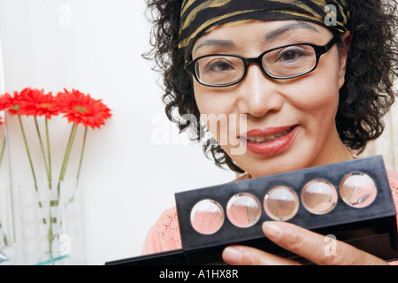 Porträt einer reifen Frau hält eine Make up kit Stockfoto