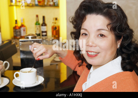 Porträt einer reifen Frau Rühren eine Tasse Kaffee Stockfoto