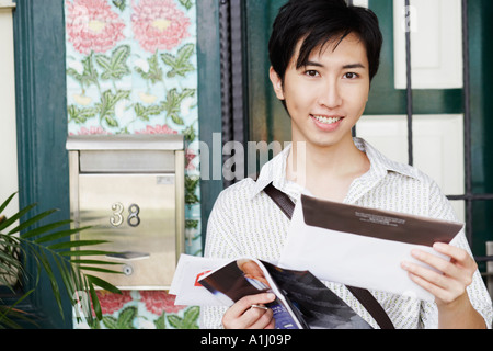 Porträt eines jungen Mannes Post halten und Lächeln Stockfoto