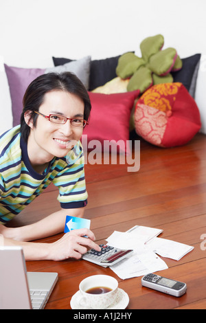 Porträt eines Mitte erwachsenen Mannes Rechnungen mit einem Taschenrechner berechnen Stockfoto