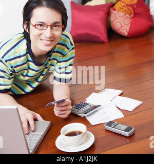 Porträt eines Mitte erwachsenen Mannes mit einem Laptop und halten eine Kreditkarte Stockfoto