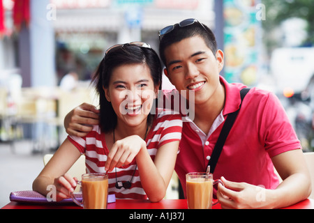 Porträt eines jungen Paares in einem Straßencafé sitzen und Lächeln Stockfoto