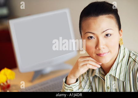 Porträt von eine Geschäftsfrau, die mit ihrer Hand unter ihr Kinn zu denken Stockfoto