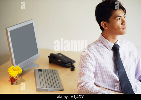 Nahaufnahme eines jungen Mannes in einem Büro sitzen und denken Stockfoto