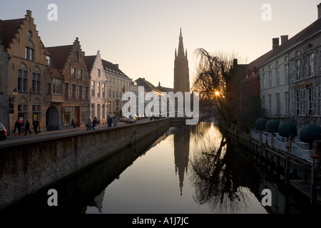 Blick auf den Kanal bei Sonnenuntergang mit Blick auf die Onze Lieve Vrouwekerk Brügge, Belgien Stockfoto