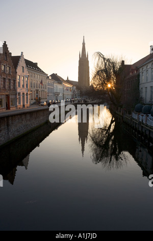 Blick auf den Kanal bei Sonnenuntergang mit Blick auf die Onze Lieve Vrouwekerk Brügge, Belgien Stockfoto