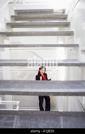 Porträt einer Geschäftsfrau hält Brillen und lächelnd Stockfoto