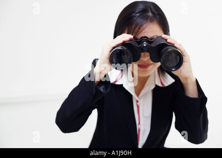 Eine Geschäftsfrau auf der Suche durch ein Fernglas in Nahaufnahme Stockfoto