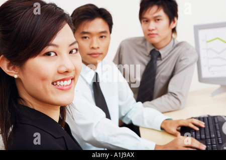 Porträt von eine Geschäftsfrau mit zwei Geschäftsleute in einem Büro sitzen und Lächeln Stockfoto