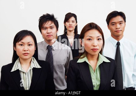 Porträt von drei Geschäftsfrauen mit zwei Geschäftsmänner stehend Stockfoto