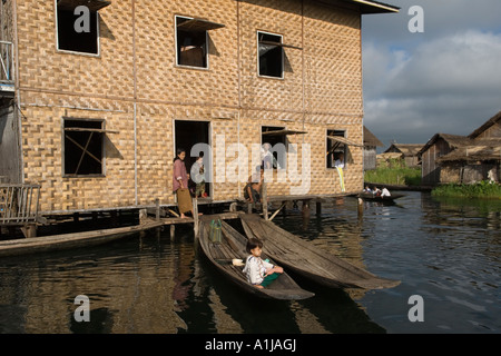 Haus auf Stelzen gebaut, Holz aber verkleidet in Rattan, Inle Lake Myanmar Burma, Kinder in Booten Familien plaudern. Shan State 2006 HOMER SYKES Stockfoto