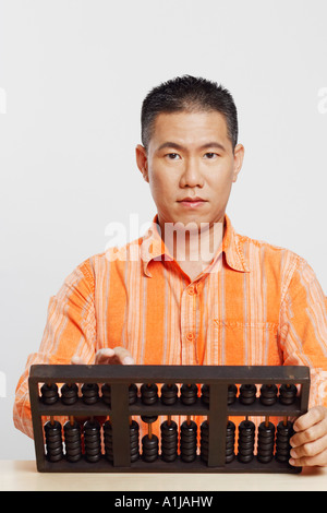 Porträt eines Mitte erwachsenen Mannes mit einem Abakus Stockfoto