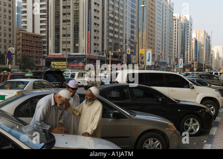 Abu Dhabi, Vereinigte Arabische Emirate VAE. Drei ausländische Arbeitskräfte Chat auf der Straße nach dem Verlassen der örtlichen Moschee. Stockfoto