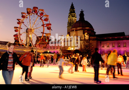 Winter-Wunderland Veranstaltung außerhalb Cardiff City Hall Wales UK mit Menschen Schlittschuhlaufen auf der Eislaufbahn und Riesenrad im Hintergrund Stockfoto