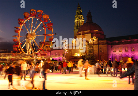 Winter-Wunderland Veranstaltung außerhalb Cardiff City Hall Wales UK mit Menschen Schlittschuhlaufen auf der Eislaufbahn und Riesenrad im Hintergrund Stockfoto