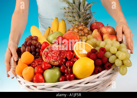 FRAU HÄLT KORB MIT FRISCHEM OBST Stockfoto