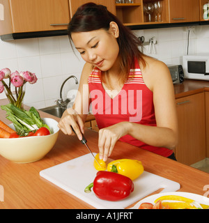 Vogelperspektive Blick auf eine junge Frau Schneiden von Gemüse in der Küche Stockfoto