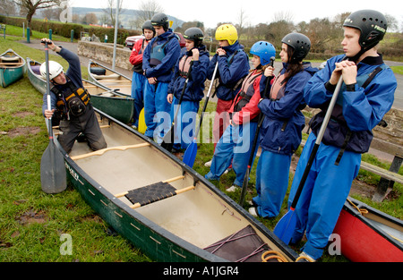 Ausbilder demonstriert offenen Kanu Technik zu Gruppe von Studenten an den Ufern des Flusses Usk bei Brecon Powys Wales UK Stockfoto