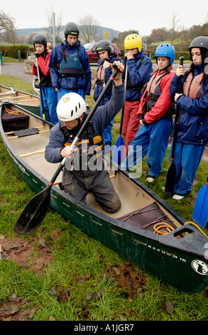 Ausbilder demonstriert offenen Kanu Technik zu Gruppe von Studenten an den Ufern des Flusses Usk bei Brecon Powys Wales UK Stockfoto