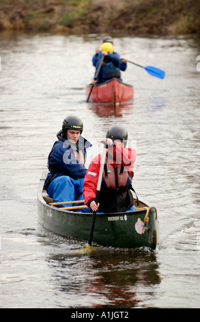 Studenten auf eine Abenteuerreise auf dem Fluss Usk in offenen Kanus bei Brecon Powys South Wales UK Stockfoto