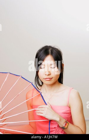 Nahaufnahme einer jungen Frau mit Sonnenschirm mit geschlossenen Augen Stockfoto