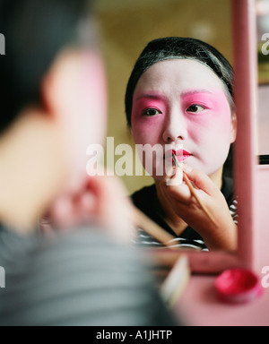 Rückansicht einer jungen Frau, die Anwendung Lipliner Stockfoto