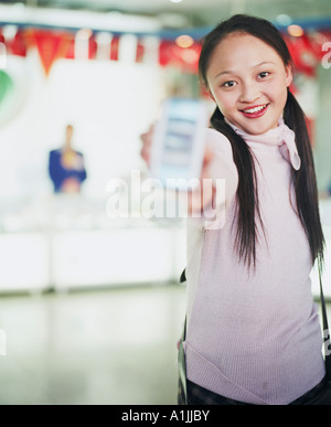 Porträt einer jungen Frau, die mit einem Mobiltelefon Stockfoto