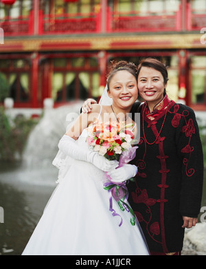 Porträt einer jungen Frau im Hochzeitskleid posiert mit einer anderen Frau Stockfoto