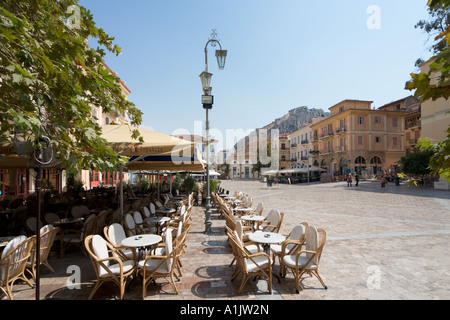 Cafe in Syntagma-Platz (Hauptplatz) mit Palamidi Burg in der Ferne, Nafplio, Peloponnes, Griechenland Stockfoto