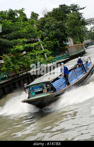 Ein lokales Wassertaxi beschleunigt durch einen Bangkok Klong (Kanal) Stockfoto