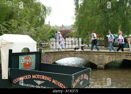 Touristen, die Überquerung der alten Steinbrücke am Bourton auf dem Wasser Stockfoto