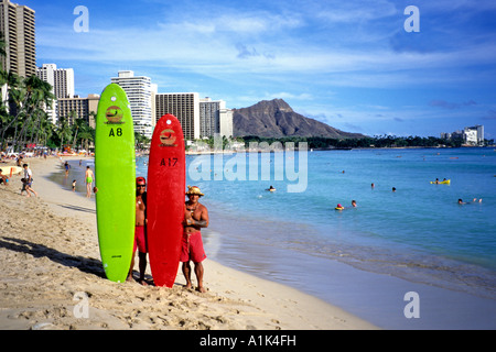 Stellen zwei Longboard-Surfer am Strand von Waikiki mit Diamond Head Honolulu Hawaii USA Stockfoto