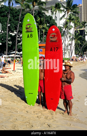 Stellen zwei Longboard-Surfer am Strand von Waikiki Honolulu Hawaii USA Stockfoto