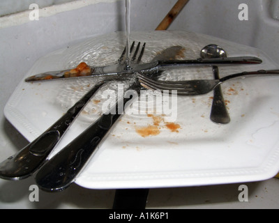 Waschbecken Sie mit schmutzigen Teller und Messer und Gabel Stockfoto