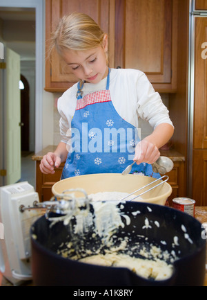 Kind, die Zugabe von Zutaten in eine Rührschüssel geben Stockfoto