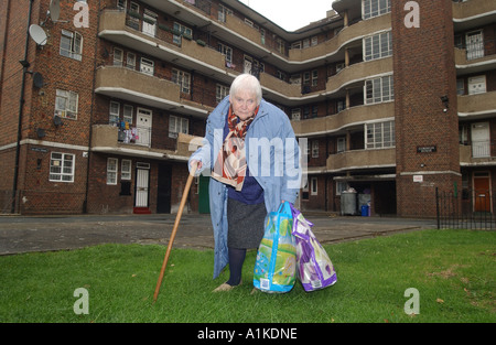 Ältere Frau Dame weiblich Einkaufstaschen auf ein Hochhaus in London Stockfoto