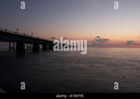 Ein Sonnenuntergang mit der Seven Mile Bridge und Wolken über dem Wasser und in den Florida Keys Stockfoto