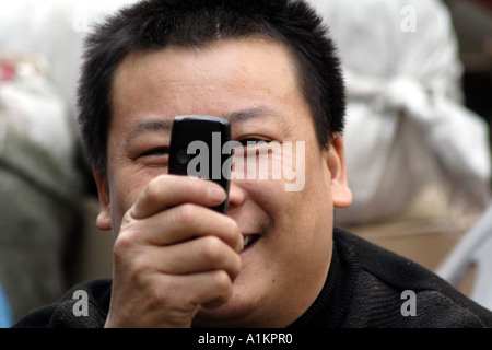 Mann, der mein Bild mit seiner Handy-Kamera.  Qingping Markt, Guangzhou, China Stockfoto