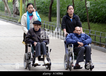 Filipina Amahs Fürsorge für ältere Hong Kong Chinese im Victoria Park in Causeway Bay, Hong Kong Stockfoto