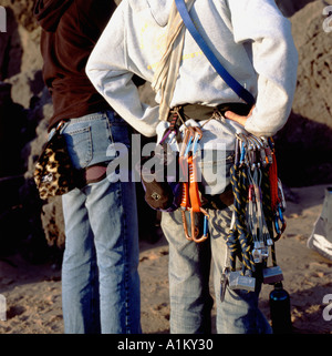 Zwei junge Männer mit Rock Kletterausrüstung Karabiner carabina Rückansicht in Three Cliffs Bay in South Wales UK KATHY DEWITT Stockfoto