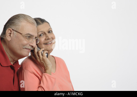 Indische Senioren Paar am Telefon auf weißem Hintergrund Stockfoto