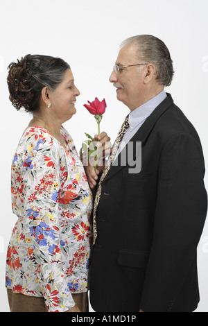 Liebevolle indische Senioren paar Mann Frau rose Blume anzubieten Stockfoto