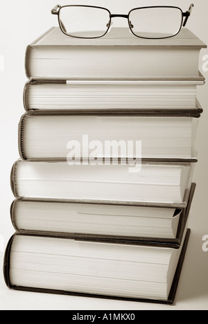 Stapel Bücher mit ein paar Brillen an der Spitze Stockfoto