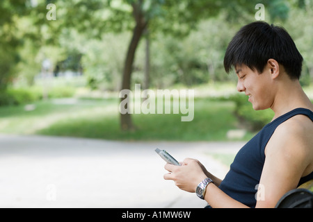 Junger Mann mit elektronischer Organizer in einem park Stockfoto