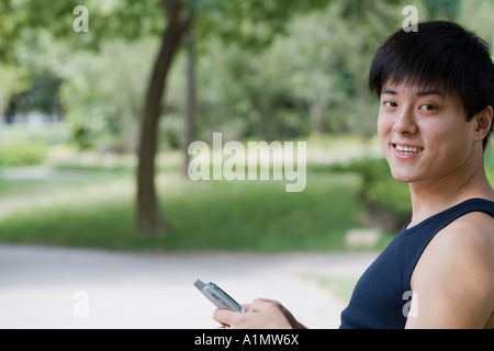 Junger Mann mit elektronischer Organizer in einem park Stockfoto