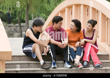 Familie sitzen zusammen auf die Brücke zu Fuß Stockfoto